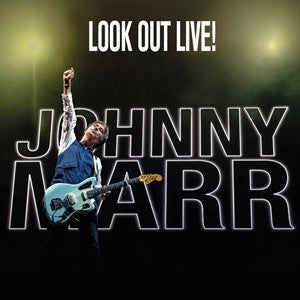 Johnny Marr performing live at Hammersmith Apollo during his 2024 Spirit Power tour, guitar in hand under stage lights, with audience in the background.