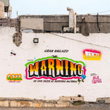 Graffiti on a wall with colorful text and logos, featuring 'The Warning' and 'Fermin Vargas'.