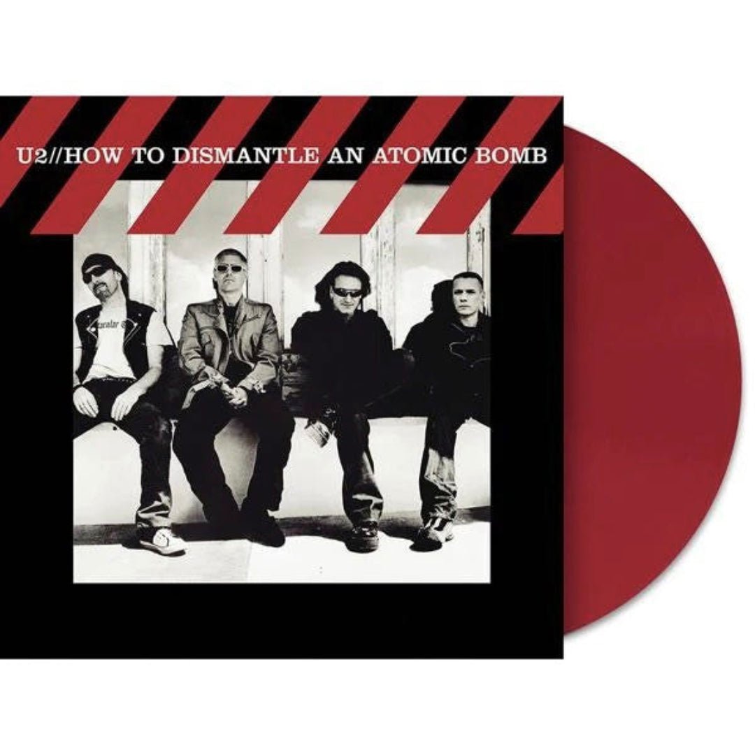 Close-up of red vinyl LP showing disc color, label, and album cover details.